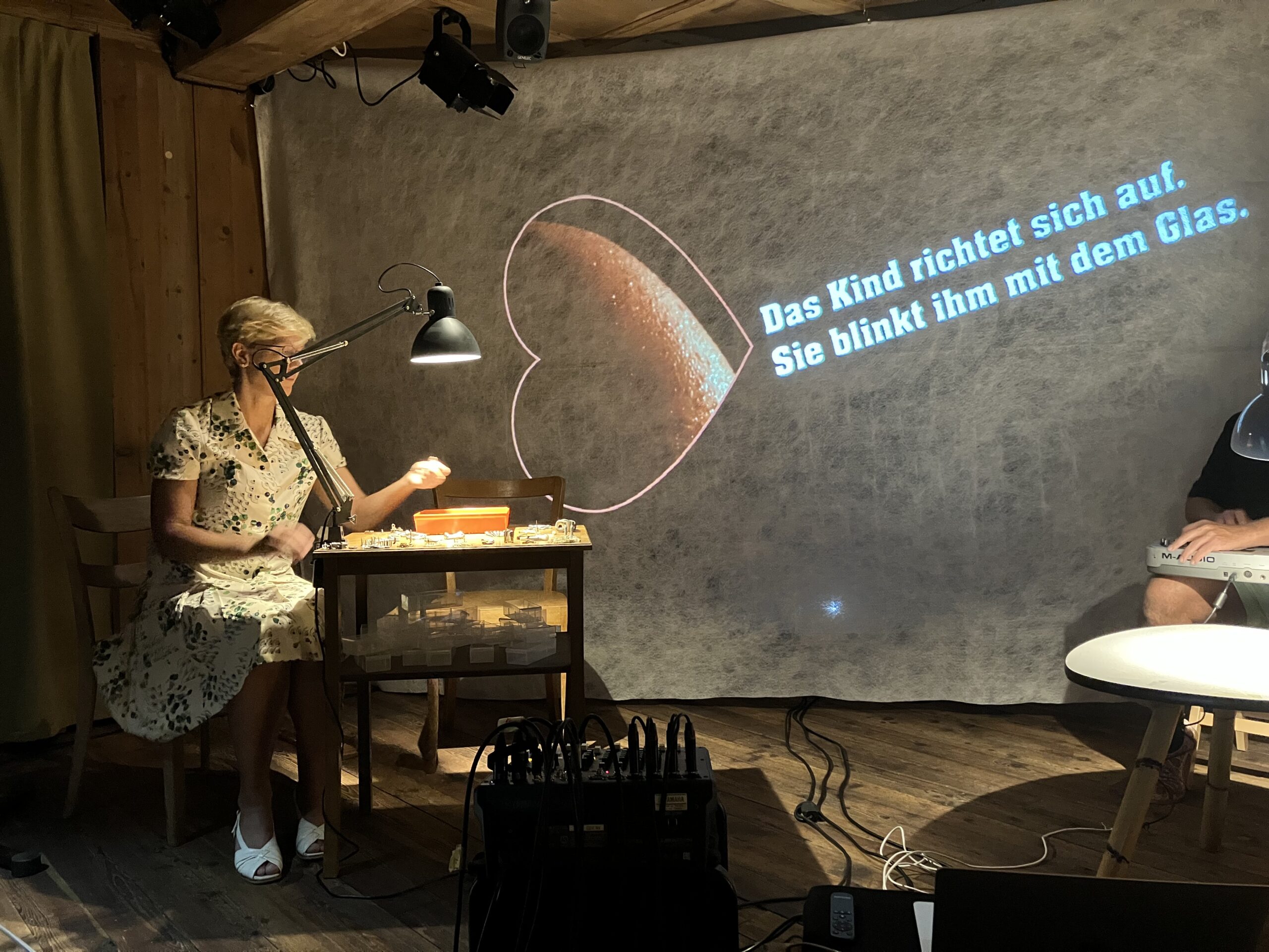An der Wand ein Herz: Das Zeichen für Marie begleitet die Live-Aktion; Projektion und Sprache greifen ineinander.