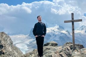 2) Pater Gerald Baumgartner auf einem Gipfelkreuz oberhalb von Zermatt